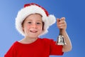 Happy child ringing bell on blue