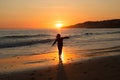 Happy child running on the beach during sunset