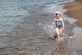 Happy child running and jumping in the waves