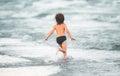 Happy child running in the sea. Kid boy having fun on the beach. Summer vacation and healthy kids. Royalty Free Stock Photo