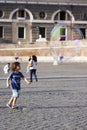 Happy child running towards a soap bubble