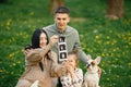 Pregnant mother and her little daughter and husband sitting on a grass in a park Royalty Free Stock Photo