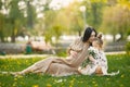 Pregnant mother and her little daughter sitting on a grass in a park Royalty Free Stock Photo