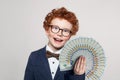 Happy child smart student boy in glasses and suit portrait with money us dollars fan