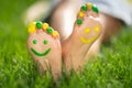 Happy child with smile on feet lying on green spring grass Royalty Free Stock Photo