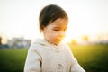 Happy child smile in outside. Caucasian girl baby play outdoor. Close up portrait of cute girl toddler looking down on green grass Royalty Free Stock Photo