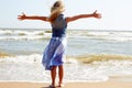 Happy child stands on the shore of the ocean