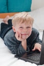 Happy child studying and using his laptop in his bedroom Royalty Free Stock Photo