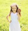 Happy child with sweet lollipop outdoors in summer