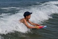 Happy child swim in the sea with a board. Swimming boy on vacation. Kids surfing, joy sport, fun holiday, water splashes Royalty Free Stock Photo