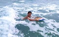 Happy child swim in the sea with a board. Swimming boy on vacation. Kids surfing, joy sport, fun holiday, water splashes Royalty Free Stock Photo