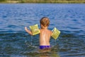 A happy child is swimming in the river on a very hot summer day. Swim in reservoirs. A happy family has fun and splashes in the