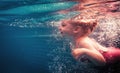 Happy child swimming underwater in swimming pool during diving training. Royalty Free Stock Photo