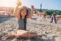 Happy child in swimsuit relaxing on the summer beach and playing with sand. Warm weather, cozy mood.