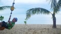 The happy child swinging on a swing on the beach. Tropical island