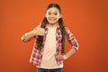 Happy child thumb up. childrens day. childhood happiness. little girl orange background. kid fashion. smiling school