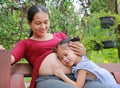 Happy child touching belly of pregnant women in the garden Royalty Free Stock Photo