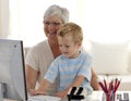 Happy child using a labtop with his grandmother