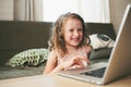 Happy child using laptop at home. School girl learning with computer and internet Royalty Free Stock Photo