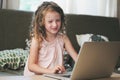 Happy child using laptop at home. School girl learning with computer and internet Royalty Free Stock Photo