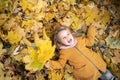 Happy child walking in autumn park. Little funny girl lies on yellow leaves in the forest. Preschooler outdoors. autumn Royalty Free Stock Photo