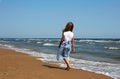 Happy child walks along the coastline ocean