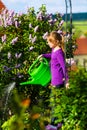 Happy child watering flowers in the garden