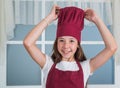 Happy child wear cook uniform. chef girl in hat and apron. kid cooking food in kitchen. choosing a career. little helper Royalty Free Stock Photo