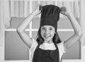 happy child wear cook uniform. chef girl in hat and apron. kid cooking food in kitchen. choosing a career. little helper Royalty Free Stock Photo