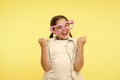 Happy child wear heart shaped glasses on yellow background. Little girl smile in fashion accessory. Funky style beauty Royalty Free Stock Photo