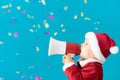 Happy child wearing Santa Claus costume speaking by megaphone Royalty Free Stock Photo