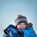 Happy child in winterwear laughing while playing in snowdrift Royalty Free Stock Photo