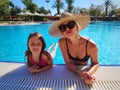 Happy child and woman playing in swimming pool. Summer vacation concept Royalty Free Stock Photo