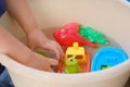 happy child 4 years old plays with rubber yellow duck for swimming, toys colored fish, boat in basin, concept of developing Royalty Free Stock Photo