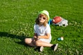 Happy childhood. Happy children rest fun outdoors. Kids relaxing in spring park. Boy sitting on green grass. Royalty Free Stock Photo