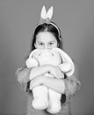 Happy childhood. Get in easter spirit. Bunny ears accessory. Lovely playful bunny child hugs soft toy. Have blessed