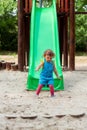 Happy childhood - girl chuting down slide at playground Royalty Free Stock Photo