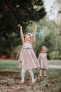 Happy childhood: Little girls having fun together outdoors in the summer park. two sisters in cute dresses are playing together Royalty Free Stock Photo