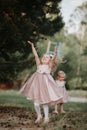 Happy childhood: Little girls having fun together outdoors in the summer park. two sisters in cute dresses are playing together Royalty Free Stock Photo