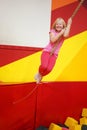 Happy childhood of a modern child in the city - girl in an amusement park riding a rope