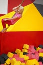 Happy childhood of a modern child in the city - girl in an amusement park riding a rope