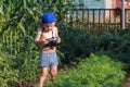 Happy childhood. Small baby is holding a camera and trying to take the photo at the garden. Little photographer Royalty Free Stock Photo