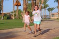 Happy childish team having fun running on path in tropic resort. Happy family team. Sisters enjoy summer vacations. People Royalty Free Stock Photo