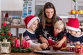 Happy children, boy brothers and mother, baking christmas cookies at home Royalty Free Stock Photo