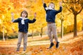 Happy children, boy brothers, playing in the park, throwing leaves Royalty Free Stock Photo