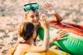 Happy kids boy and girl with an inflatable swimming circle, play and have fun sitting on the sand on the beach Royalty Free Stock Photo