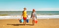 Happy children boy and girl playing on the beach on summer holidays. Kid in nature with blue sea, sand and blue sky Royalty Free Stock Photo