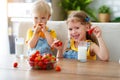 Happy children brother and sister eating strawberries with milk Royalty Free Stock Photo