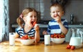 Happy children brother and sister eating strawberries with milk Royalty Free Stock Photo