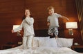 Happy children brother and sister jump on bed in bedroom